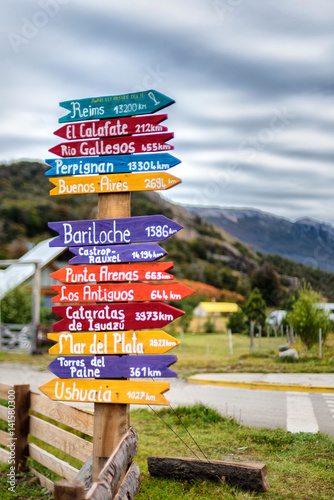 Colorful direction and city sign post in El Chalten, Argentina with Patagonia mountains in background
