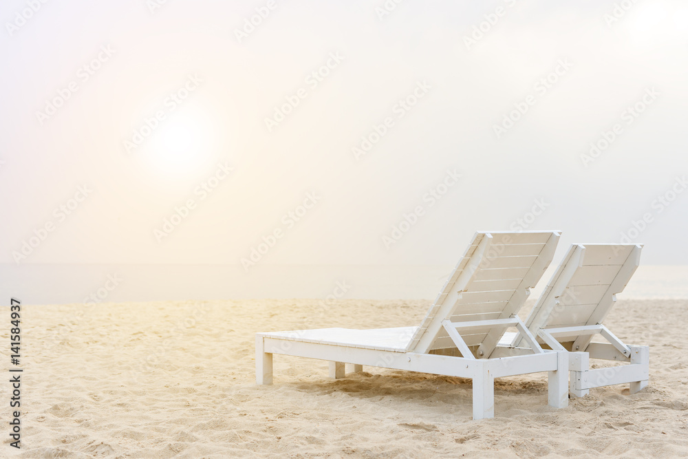 Two chairs on stunning tropical beach with bright sun