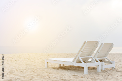 Two chairs on stunning tropical beach with bright sun