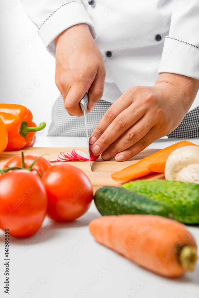 close up hands of chef cut radish slices on a wooden board close up hands of chef cut radish slices on a wooden board