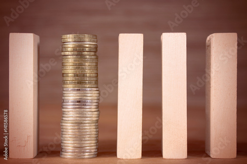 Wooden domino and a column of coins