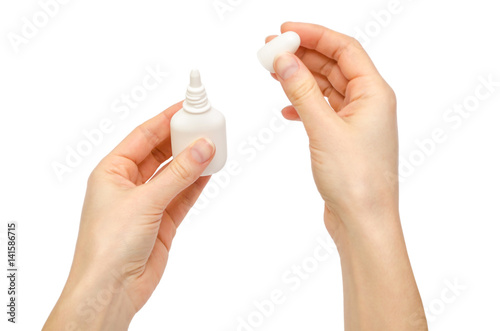 hand of young girl holding nose or eye drops.