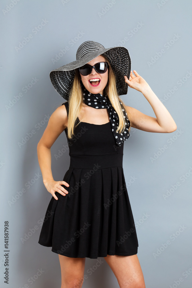 Happy young woman wearing a hat and sunglasses