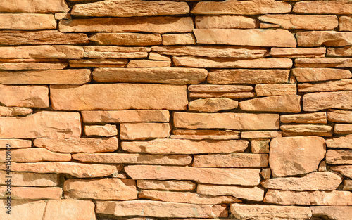 Sand colored stone setting. Stone wall texture.