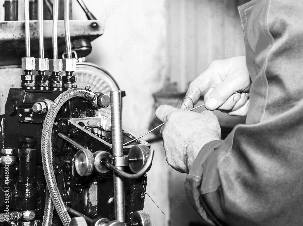 Professional mechanics testing diesel injector in his repair