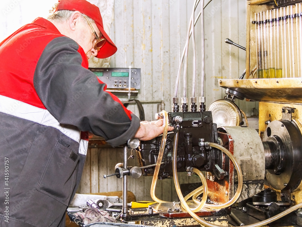Professional mechanics testing diesel injector in his repair of diesel fuel injectors