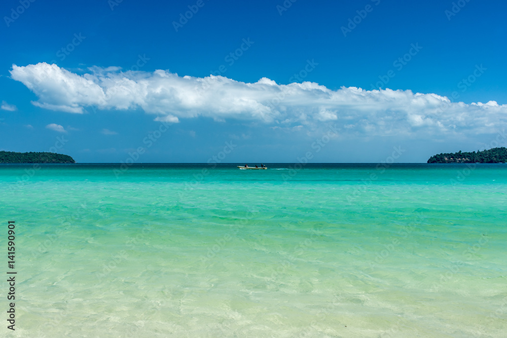 Tropical bay with a blue sky and clear calm water.