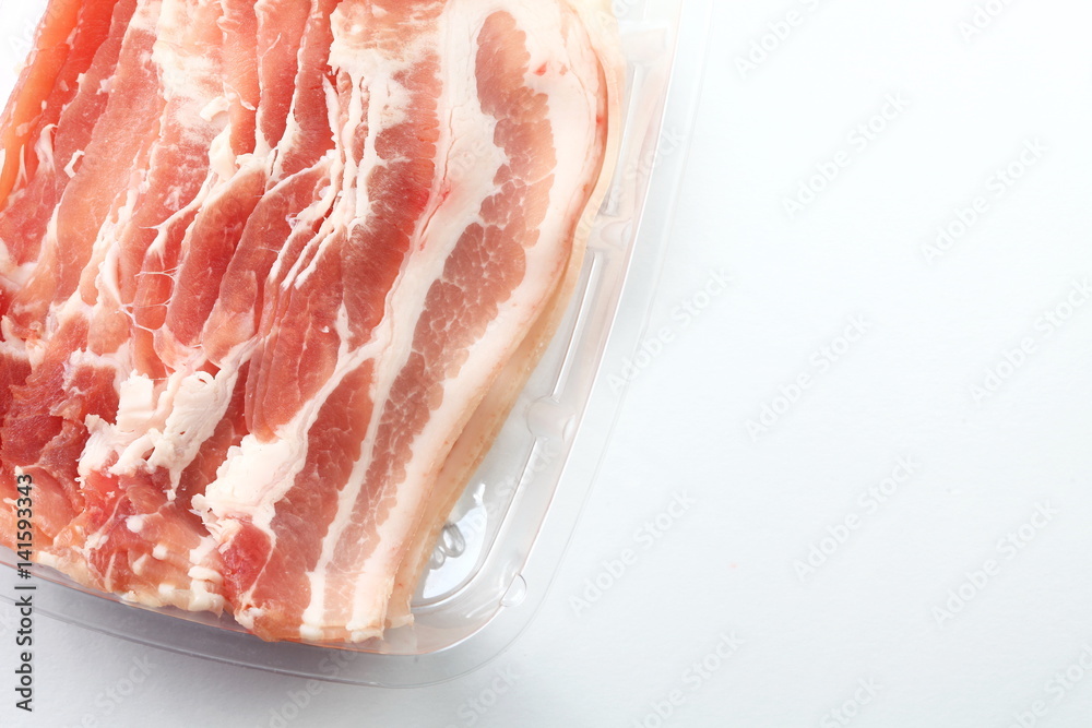 The fresh slide bacon in food grade transparent packaging represent the raw material and meat concept related idea. The fresh slide bacon in food grade transparent packaging represent the raw material and meat concept related idea.
