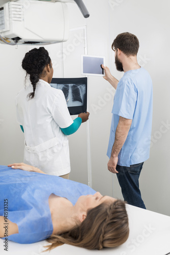 Radiologists Holding X-ray And Digital Tablet With Patient In Fo