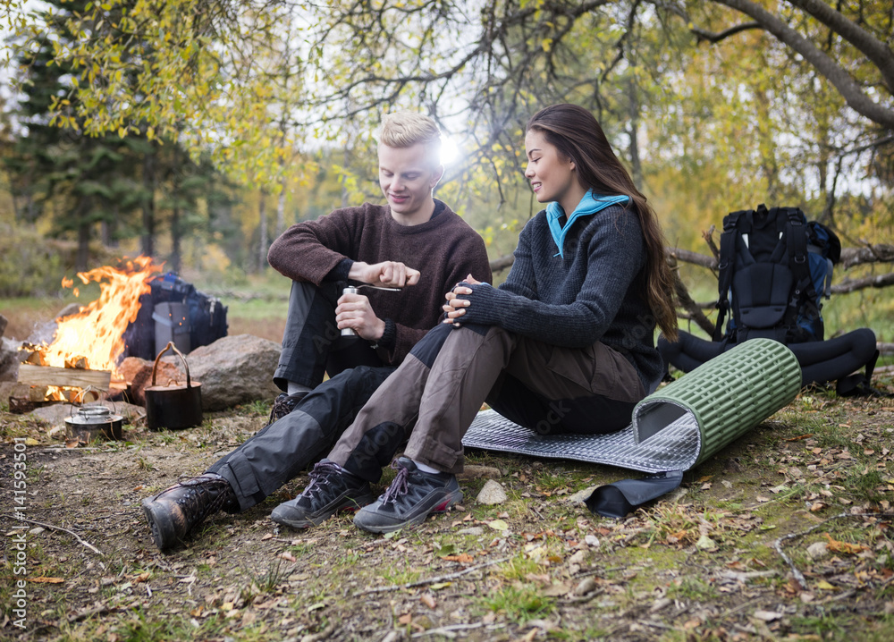 Woman With Man Grinding Coffee During Camping In Forest Woman With Man Grinding Coffee During Camping In Forest