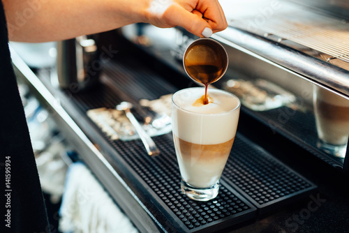 Close-up of barista preparing caffe latte photo