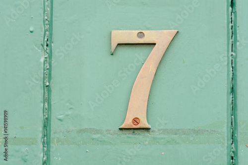 House number 7 sign on green painted door