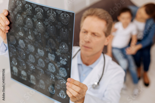 Quadro em tela Worried focused neurosurgeon examining patients x-ray