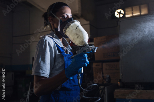 female mechanic using a paint spray gun photo