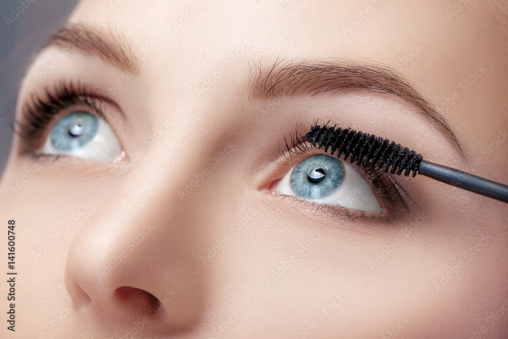 Naklejka premium Mascara brush close up. Make-up for blue eyes. Mascara applying