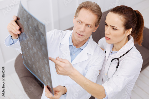 Quadro su tela Prominent doctor and his intern discussing the diagnosis