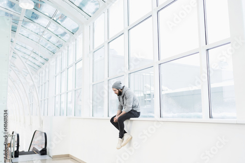 Wallpaper Mural Upset bearded man sitting on window sill Torontodigital.ca