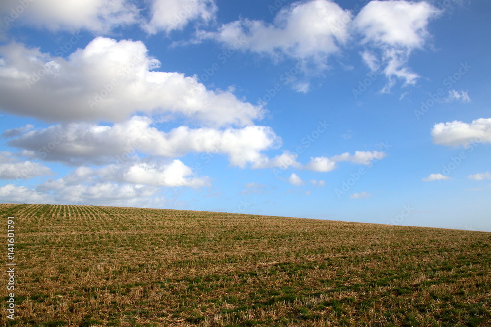 Hilly terrain with blue sky and clouds in March