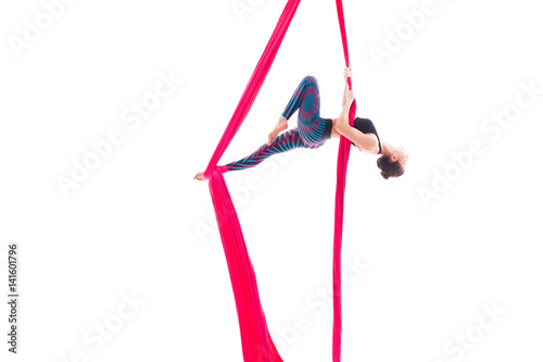 Woman hanging in aerial silks, isolated on white