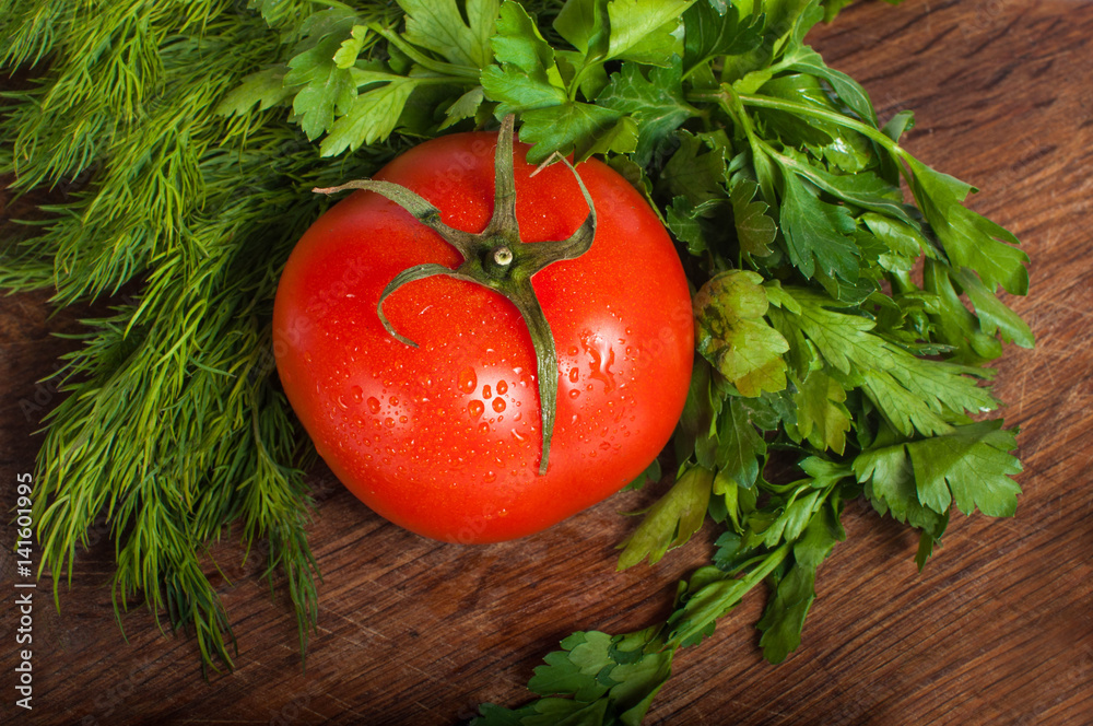 Red tomatoes with parsley on a wooden board Red tomatoes with parsley on a wooden board