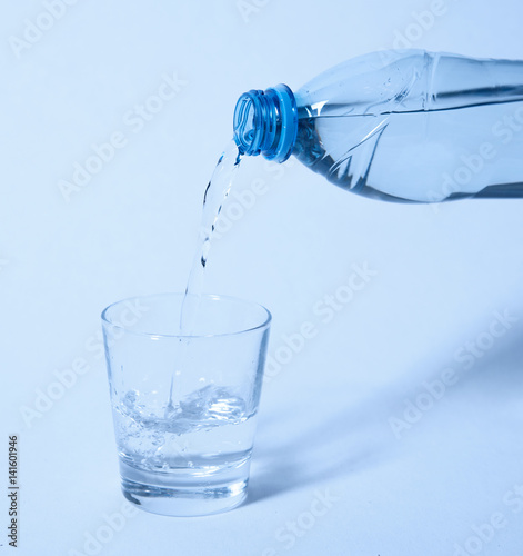 Water pouring from bottle into the glass