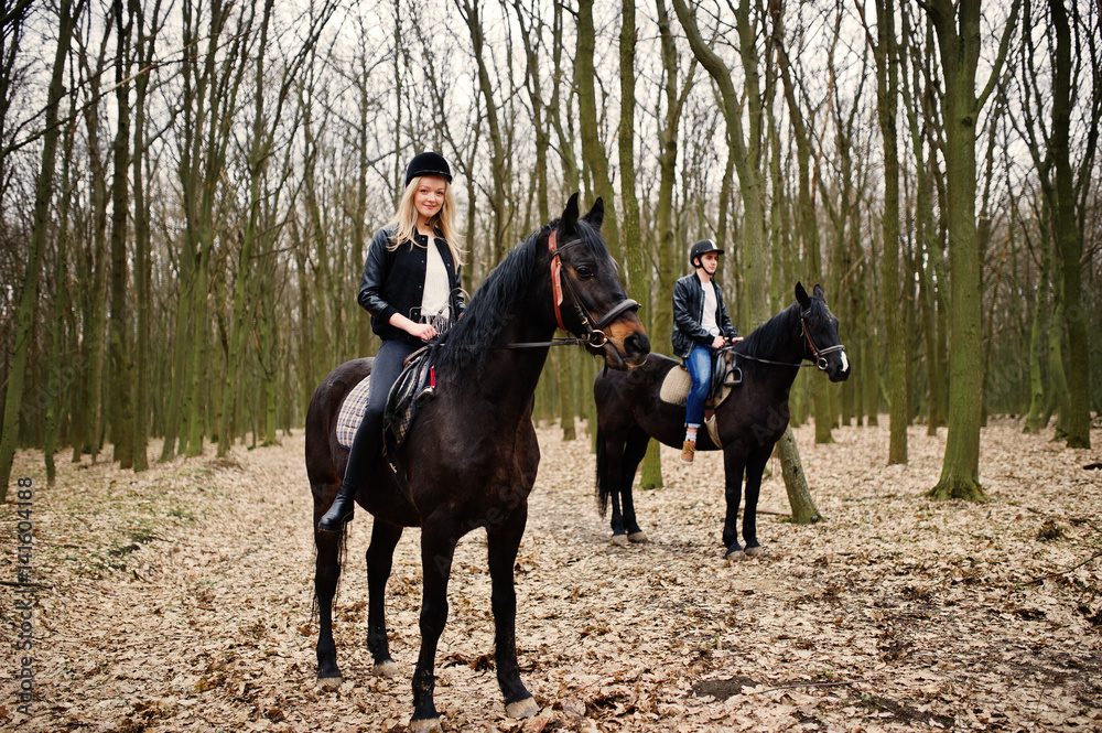Young stylish couple riding on horses at autumn forest. Young stylish couple riding on horses at autumn forest.
