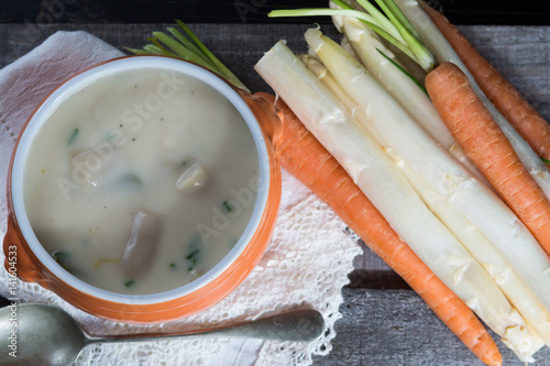 Spring season - white Dutch asparagus soup, ready to eat served in orange bowl