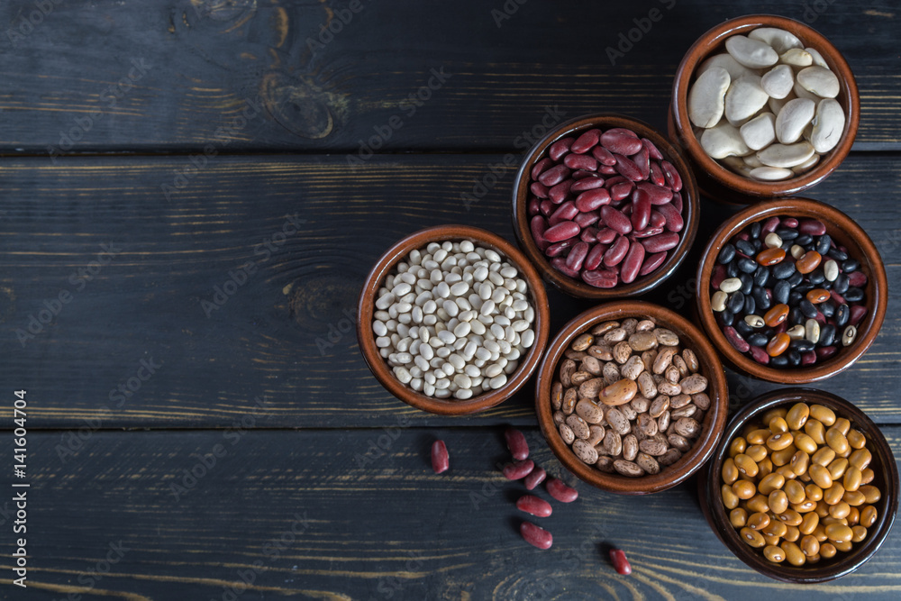 Assortment of beans on wooden background. Soybean, red kidney bean, black bean,white bean, red bean and brown pinto beans