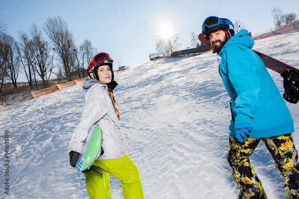 Man and woman with snowboards