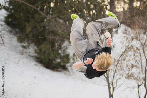 Backflip parkour jumping in winter snow park - free-run training photo