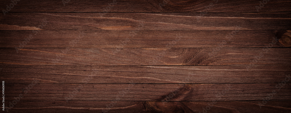 Obraz premium Ciemnobrązowa porysowana drewniana deska do krojenia. Drewno tekstura tło