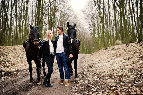 Young stylish couple in love near horses at autumn forest. © AS Photo Family