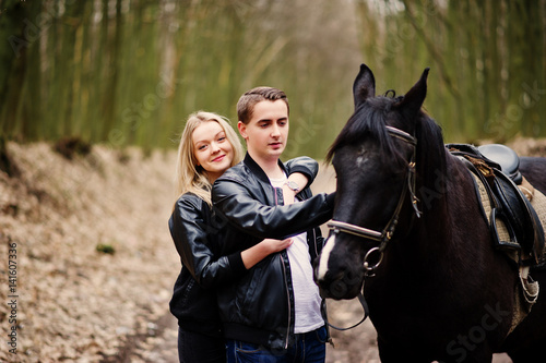 Young stylish couple in love near horse at autumn forest. © AS Photo Family