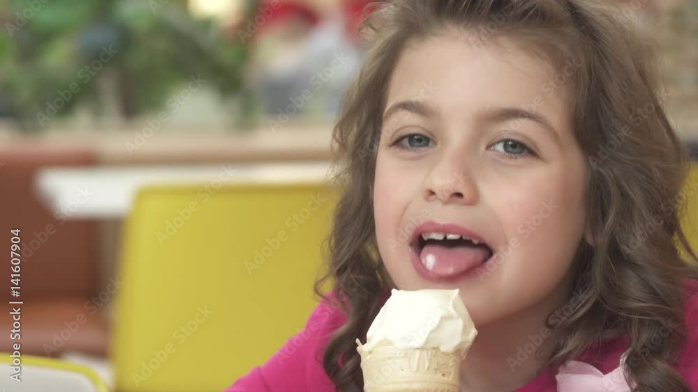 Happy and happy little girl eating ice cream at a cafe Happy and happy little girl eating ice cream at a cafe