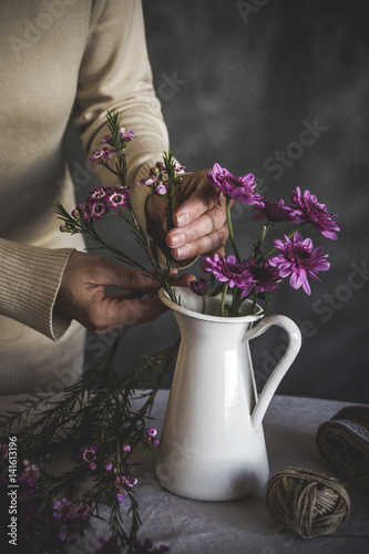 Midsection of woman arranging flowers in vase photo