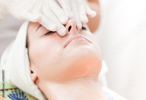 Facial massage.Beautiful young woman receiving facial massage at spa