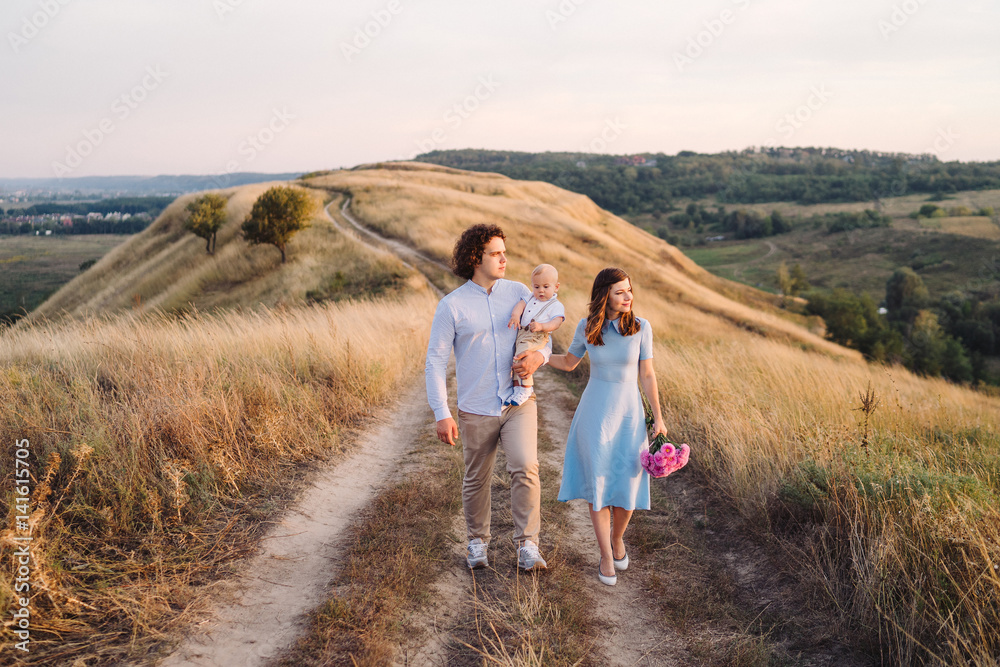Young happy caucasian couple with little baby boy. Parents and son walking and having fun together. Mother and father playing with toddler outdoors. Family, parenthood, childhood, happiness concept. Young happy caucasian couple with little baby boy. Parents and son walking and having fun together. Mother and father playing with toddler outdoors. Family, parenthood, childhood, happiness concept.