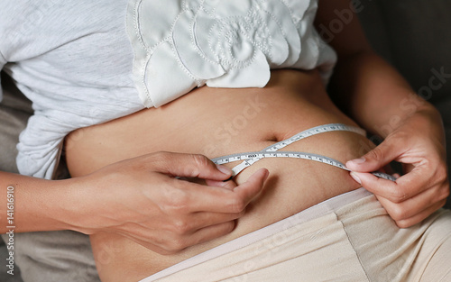 Woman body fat overweight. measure tape or line tape.