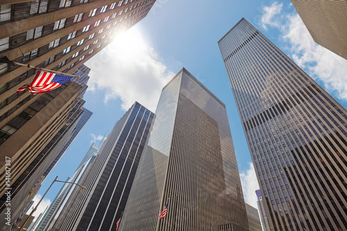 Photo of skyscrapers in Manhattan against the sun  looking up perspective  New York City  USA. 