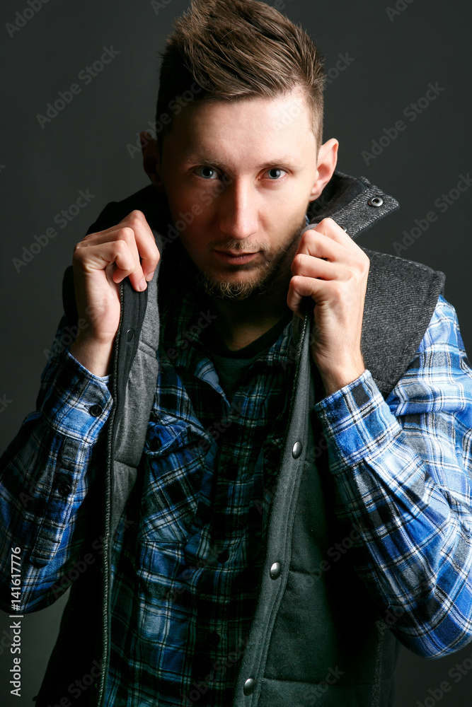 Fototapeta premium Man holds up his collar posing for the camera