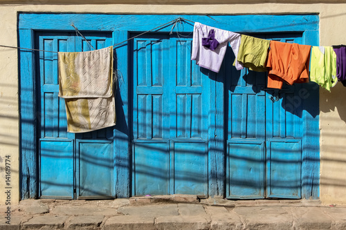 Blue window shutters with hanging laundry, Dhulkihel, Nepal photo