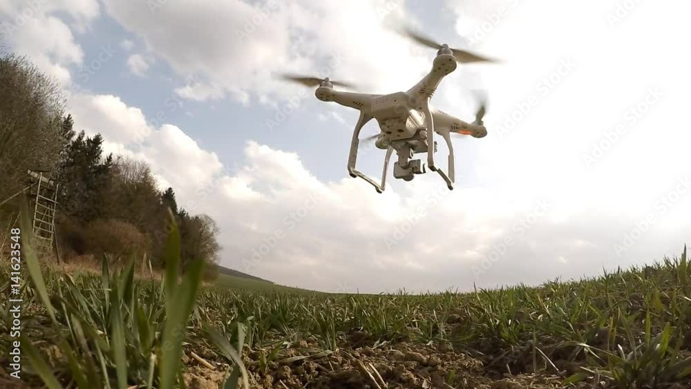 Drone flight over wheat field. Young seedlings in brown soil. New tool for farmers use drones to inspect of cultivated fields. Modern technology in agriculture. Drone flight over wheat field. Young seedlings in brown soil. New tool for farmers use drones to inspect of cultivated fields. Modern technology in agriculture.