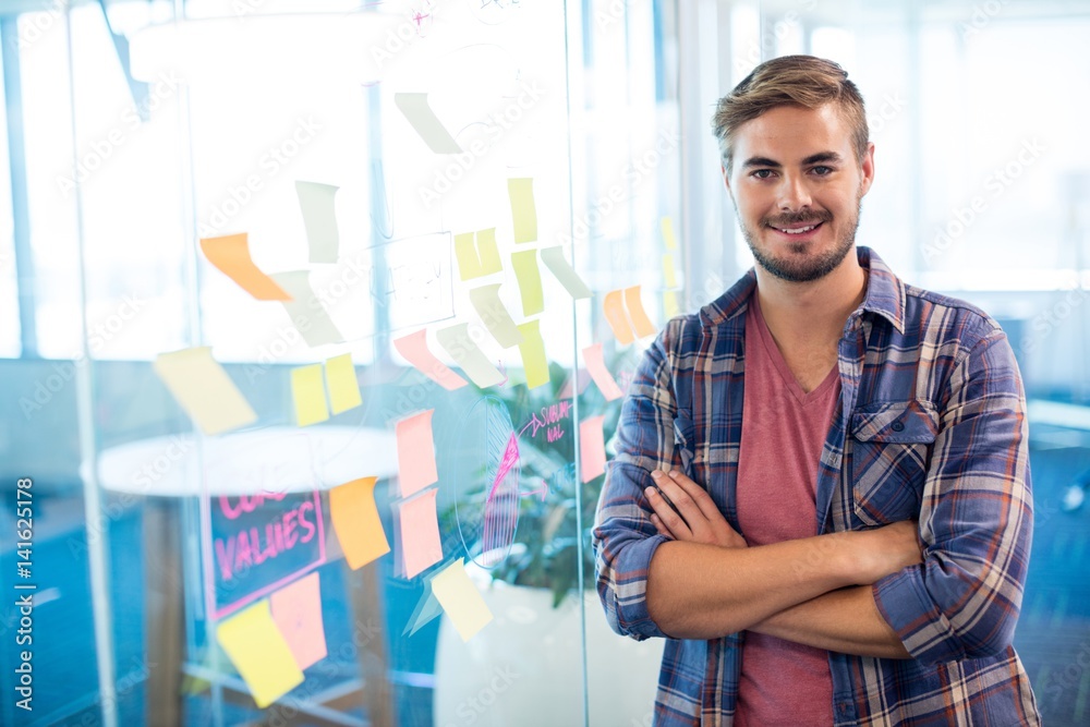 Fototapeta premium Man standing next to the sticky notes on wall in office