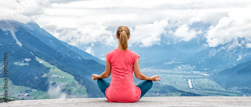 Photography young woman meditate on top of the mountain
