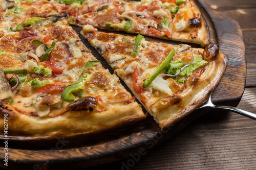Bild auf Leinwand Delicious pizza with mushrooms - thin pastry crust isolated at wooden background