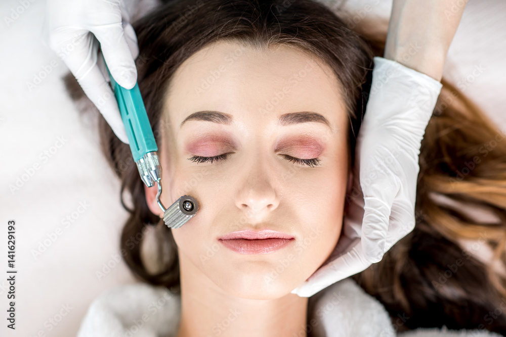 Making dry needlying procedure on woman's face in the cosmetology office Making dry needlying procedure on woman's face in the cosmetology office