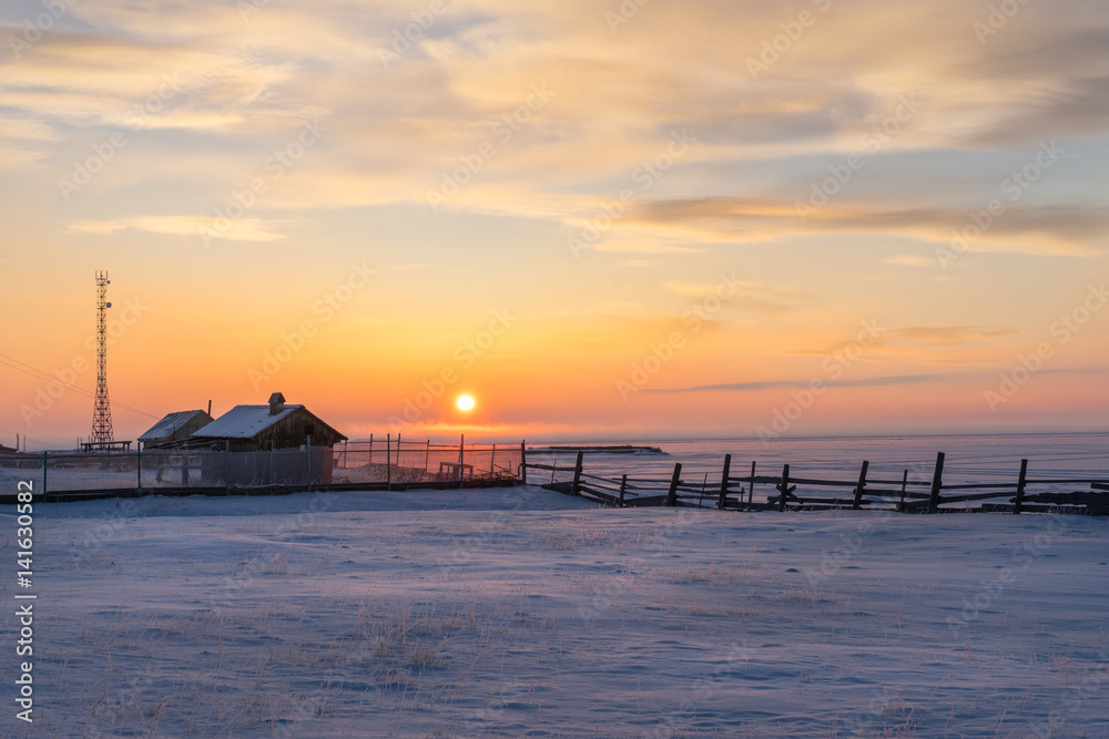 Beautiful sunset view of a small village of frozen Baikal lake during winter