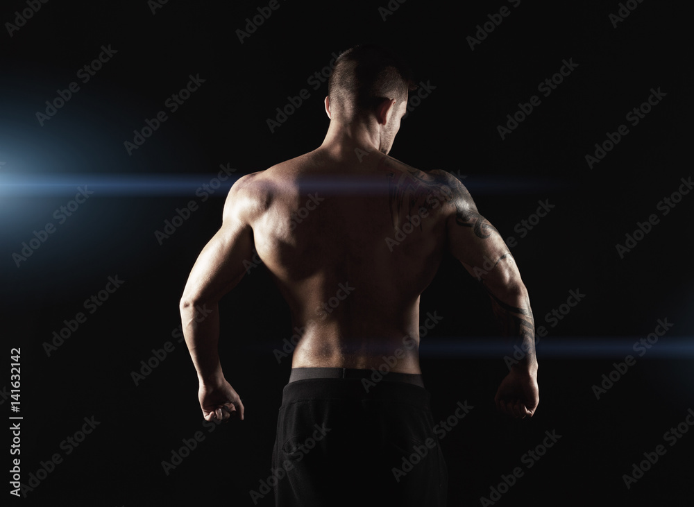 Unrecognizable man shows strong back muscles closeup