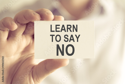 Businessman holding LEARN TO SAY NO message card