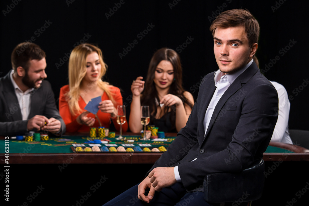 Poker players in casino with cards and chips on black background Poker players in casino with cards and chips on black background
